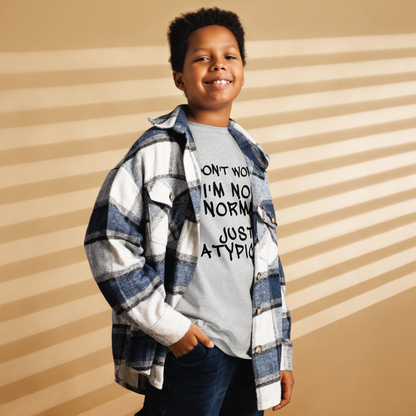 "Don't Worry I'm Not Normal Just Atypical" printed on a sport grey youth classic tee worn by a male also wearing a jacket