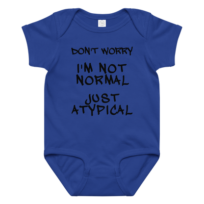 "Don't Worry I'm Not Normal Just Atypical" printed on a royal baby jersey bodysuit laying on a flat surface amongst other clothes