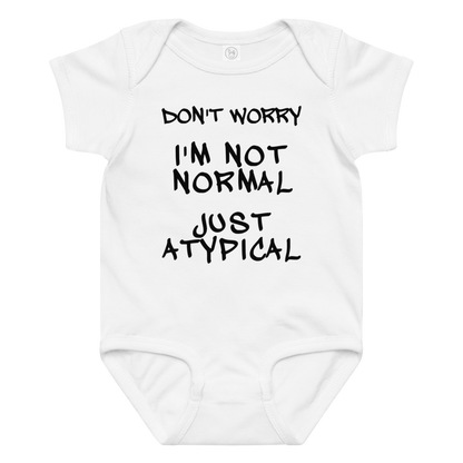"Don't Worry I'm Not Normal Just Atypical" printed on a white baby jersey bodysuit laying on a flat surface amongst other clothes
