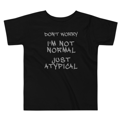 "Don't Worry I'm Not Normal Just Atypical" printed on a black toddler short sleeve tee laying on a flat surface
