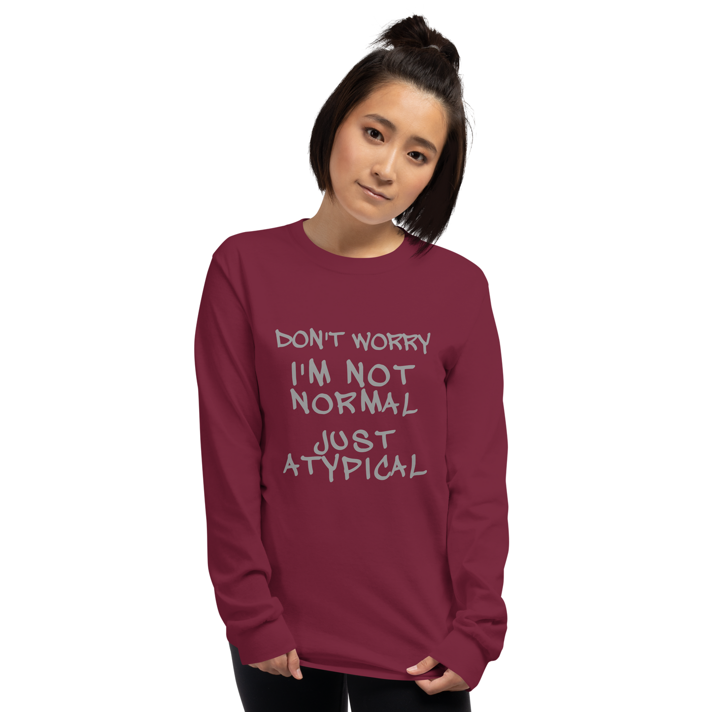 "Don't Worry I'm Not Normal Just Atypical" printed on a maroon men's long sleeve shirt worn by a female
