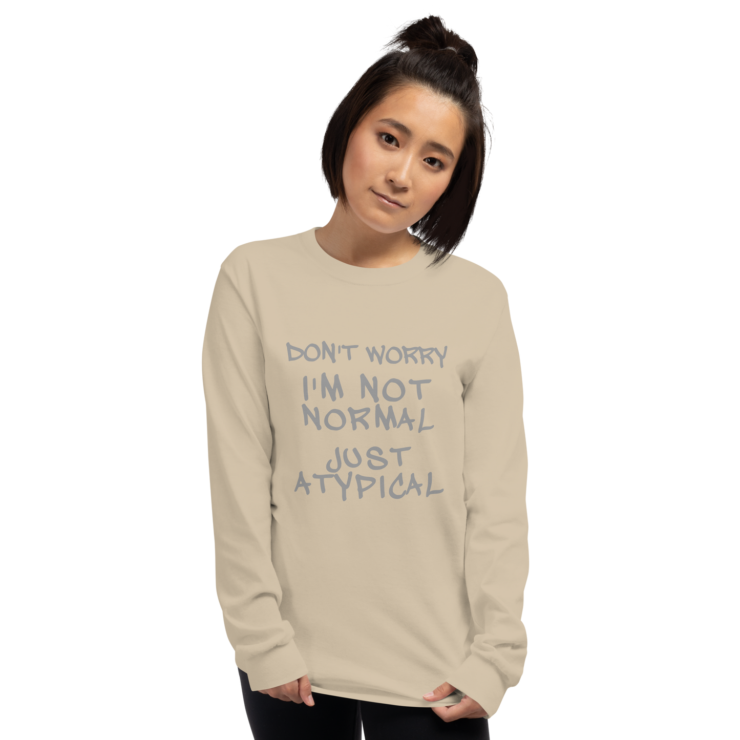 "Don't Worry I'm Not Normal Just Atypical" printed on a sand men's long sleeve shirt worn by a female