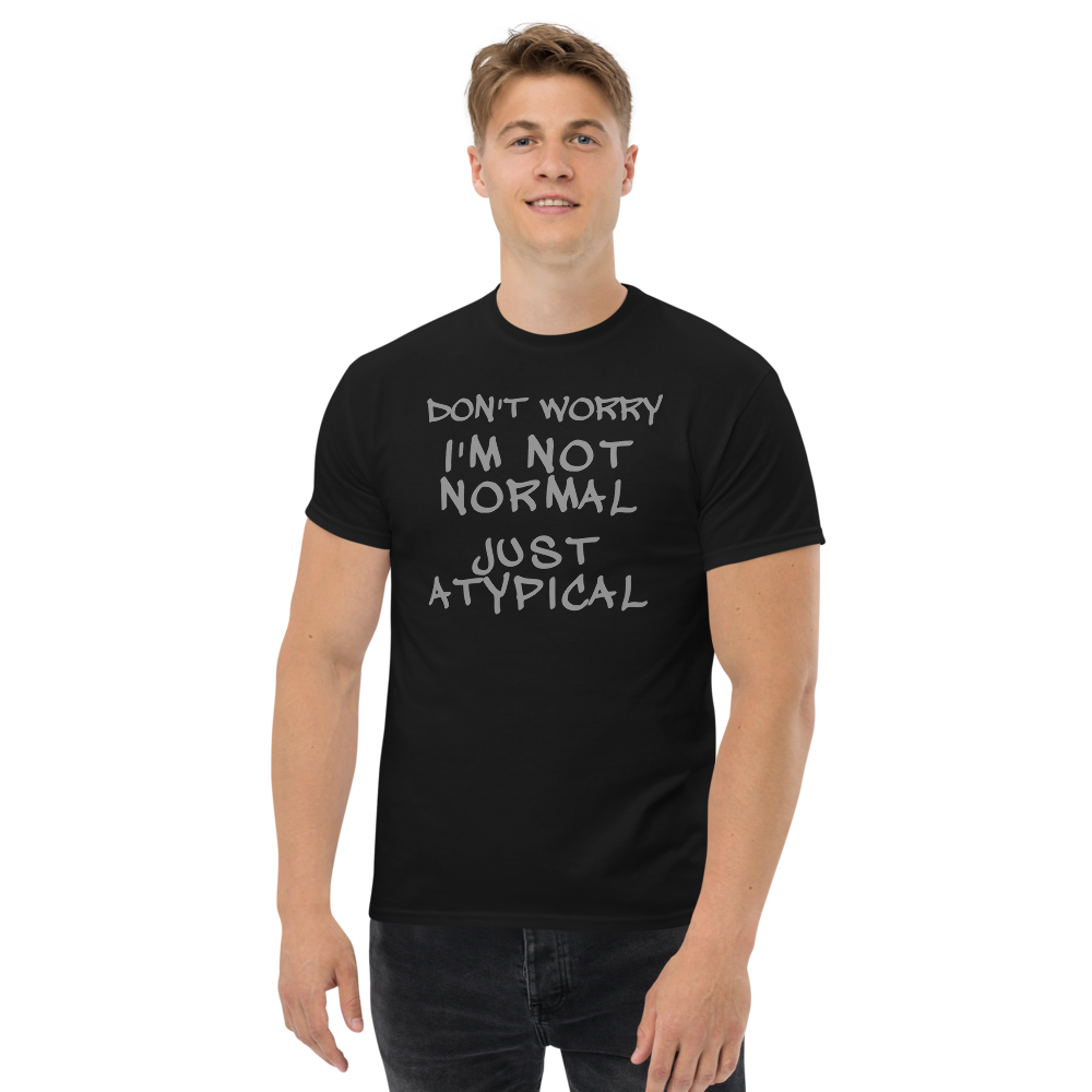 "Don't Worry I'm Not Normal Just Atypical" printed on a black unisex classic tee worn by a male