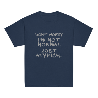"Don't Worry I'm Not Normal Just Atypical" printed on a navy youth classic tee laying on a flat surface