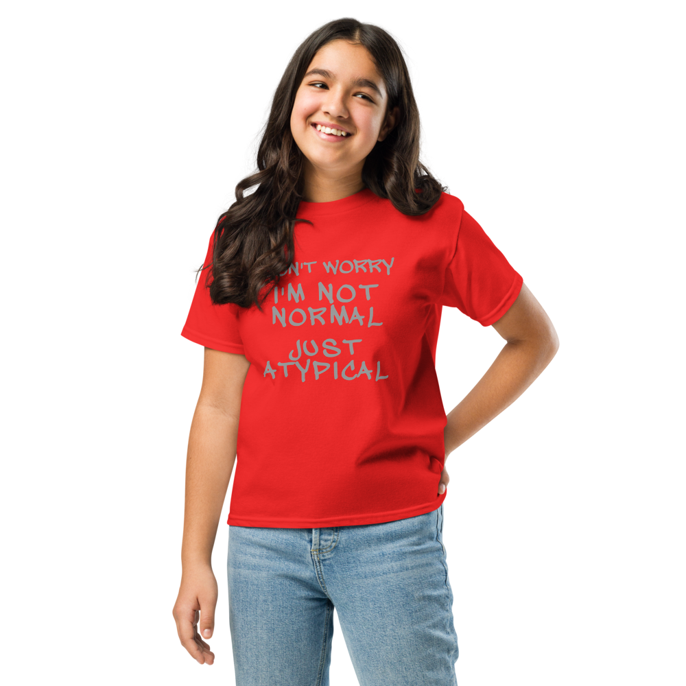 "Don't Worry I'm Not Normal Just Atypical" printed on a red youth classic tee worn by a female