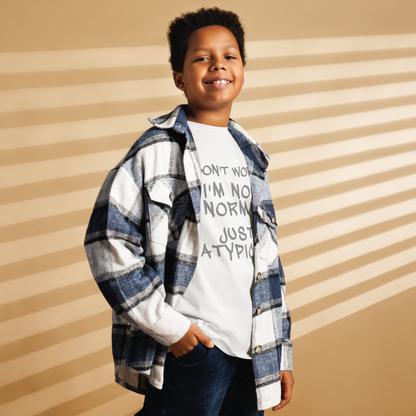 "Don't Worry I'm Not Normal Just Atypical" printed on a white youth classic tee worn by a male also wearing a jacket