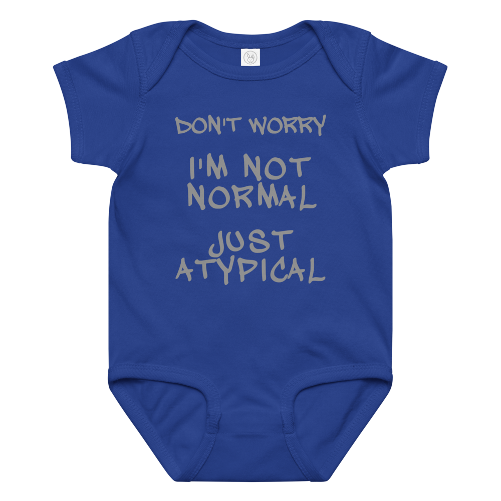 "Don't Worry I'm Not Normal Just Atypical" printed on a royal baby jersey bodysuit laying on a flat surface amongst other clothes