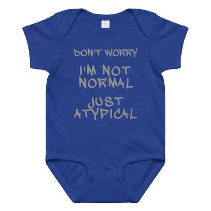 "Don't Worry I'm Not Normal Just Atypical" printed on a royal baby jersey bodysuit laying on a flat surface amongst other clothes