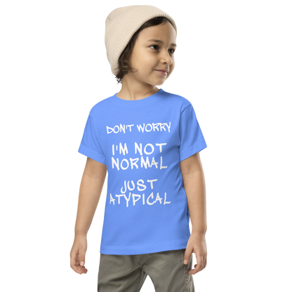 "Don't Worry I'm Not Normal Just Atypical" printed on a heather columbia blue toddler short sleeve tee worn by a male wearing a cap