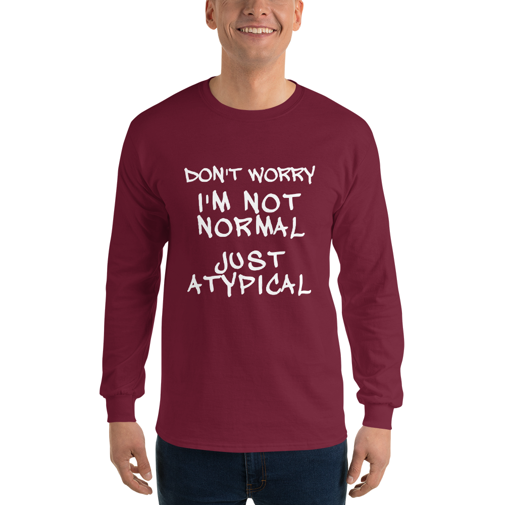 "Don't Worry I'm Not Normal Just Atypical" printed on a maroon men's long sleeve shirt worn by a male