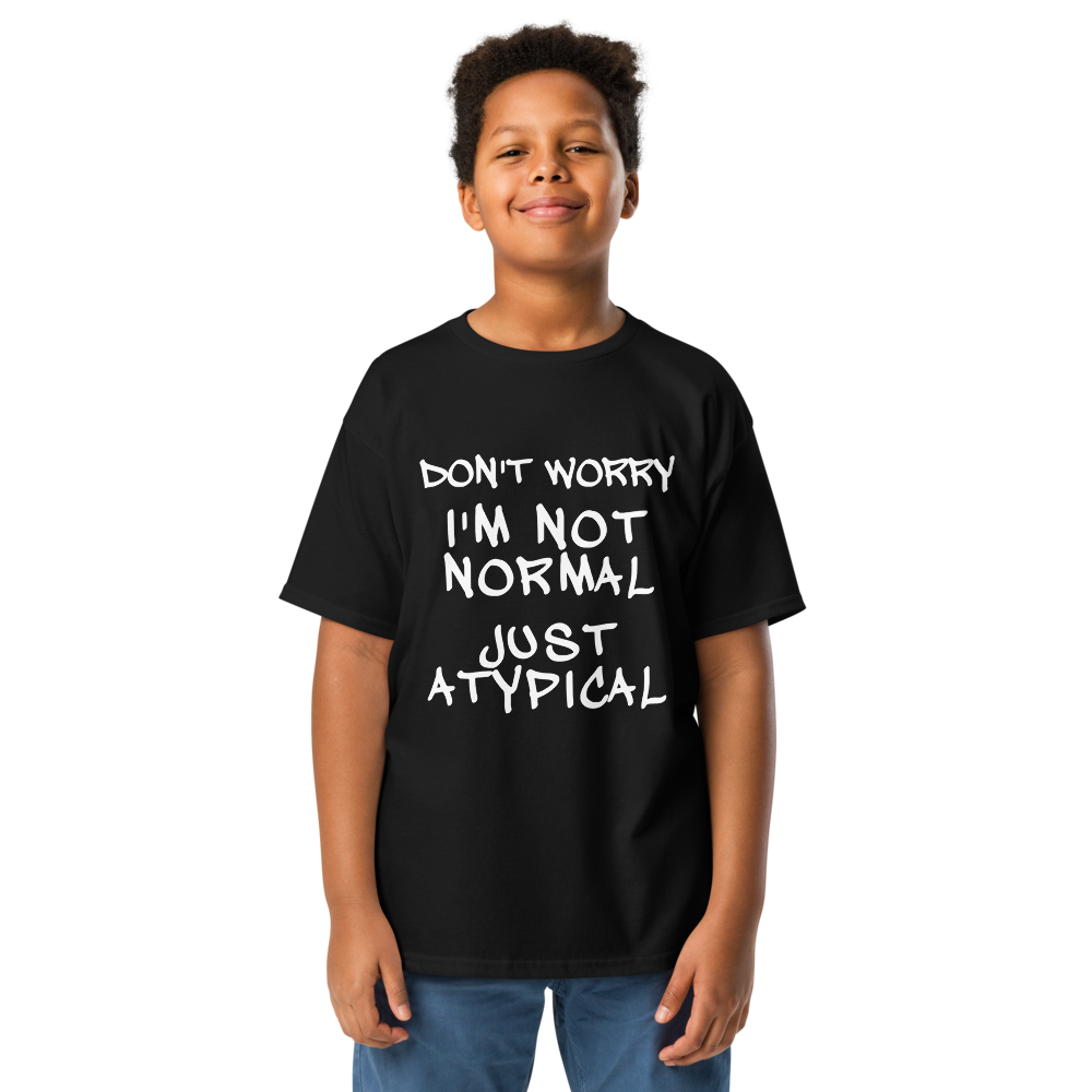 "Don't Worry I'm Not Normal Just Atypical" printed on a black youth classic tee worn by a male