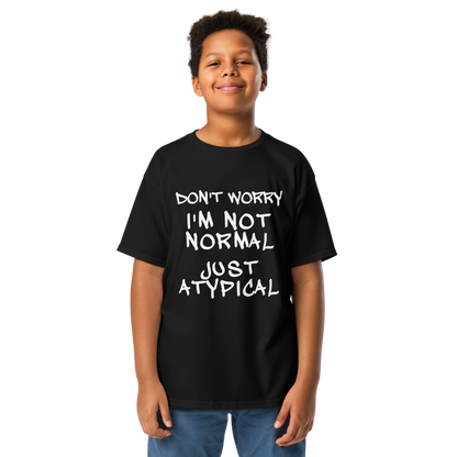 "Don't Worry I'm Not Normal Just Atypical" printed on a black youth classic tee worn by a male