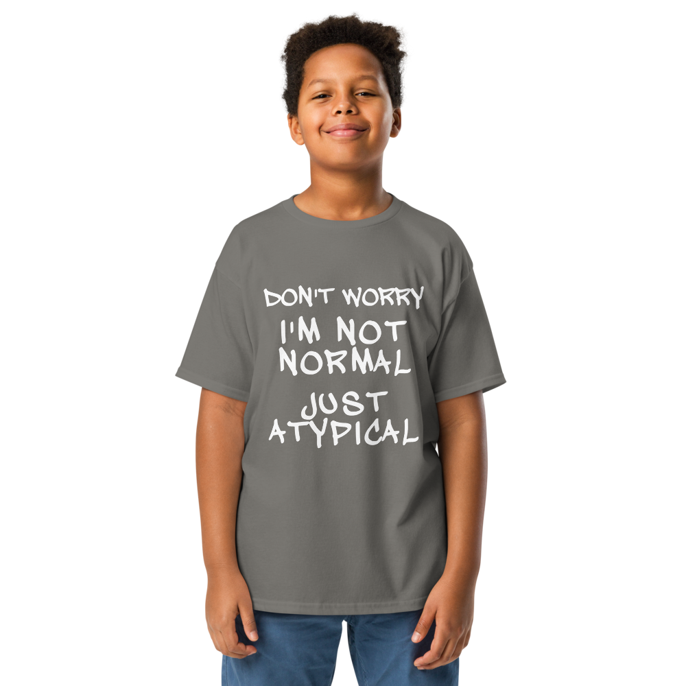 "Don't Worry I'm Not Normal Just Atypical" printed on a charcoal youth classic tee worn by a male