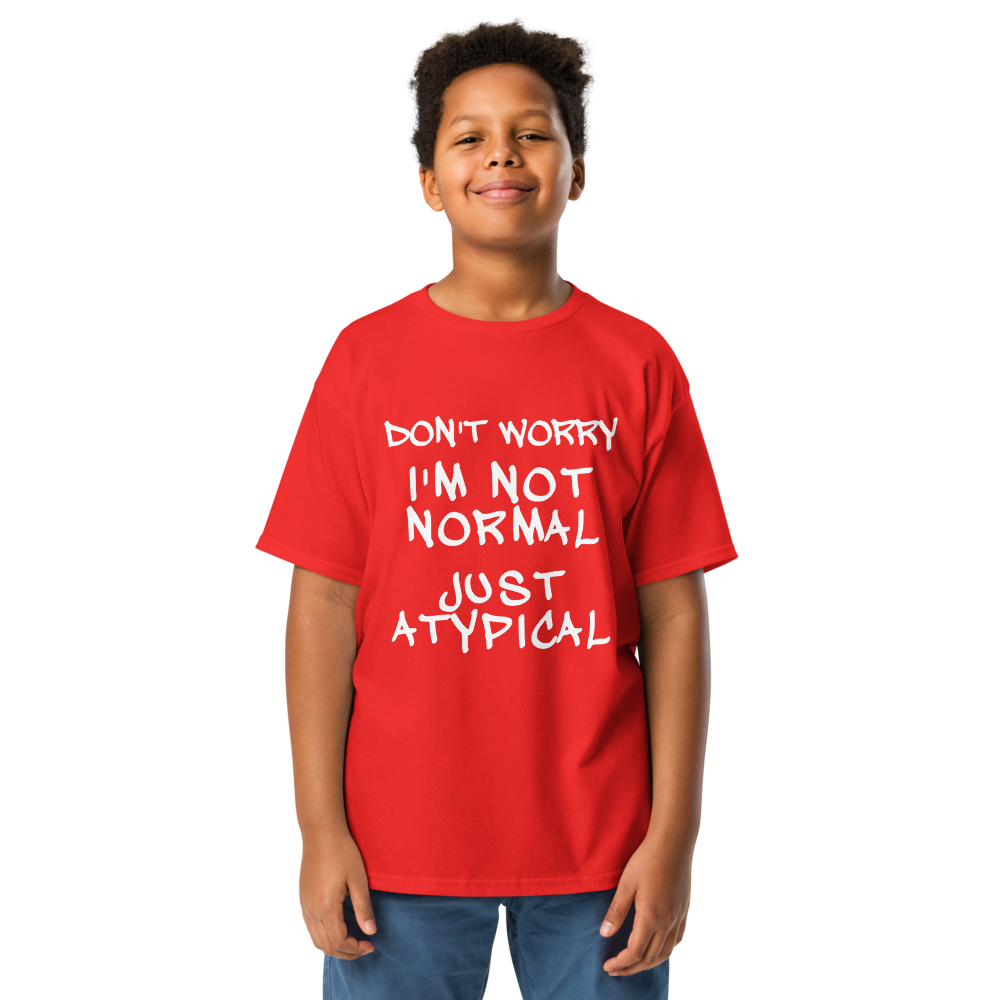 "Don't Worry I'm Not Normal Just Atypical" printed on a red youth classic tee worn by a male