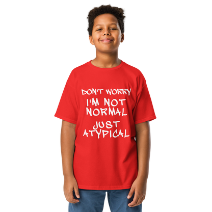 "Don't Worry I'm Not Normal Just Atypical" printed on a red youth classic tee worn by a male