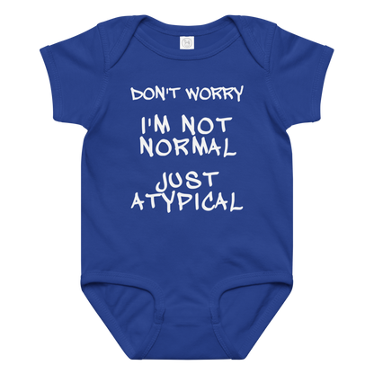 "Don't Worry I'm Not Normal Just Atypical" printed on a royal baby jersey bodysuit laying on a flat surface amongst other clothes