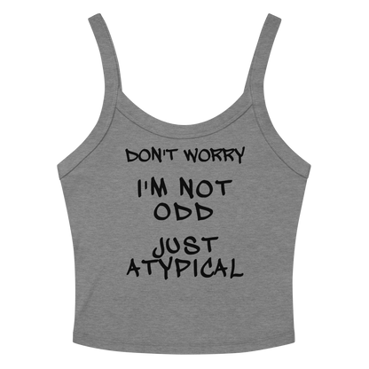 "Don't Worry I'm Not Odd Just Atypical" printed on a athletic heather women's micro-rib tanktop laying on a flat surface amongst sunglasses and shorts