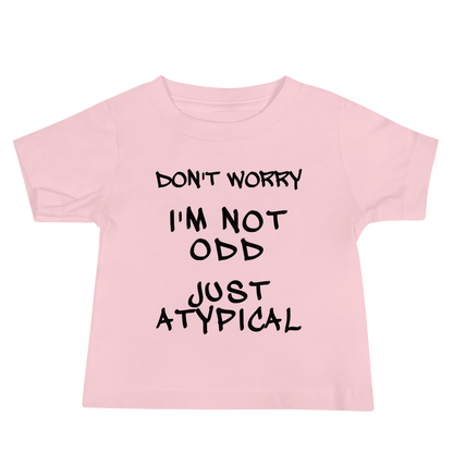 "Don't Worry I'm Not Odd Just Atypical" printed on a pink baby jersey short sleeve tee laying on a flat surface