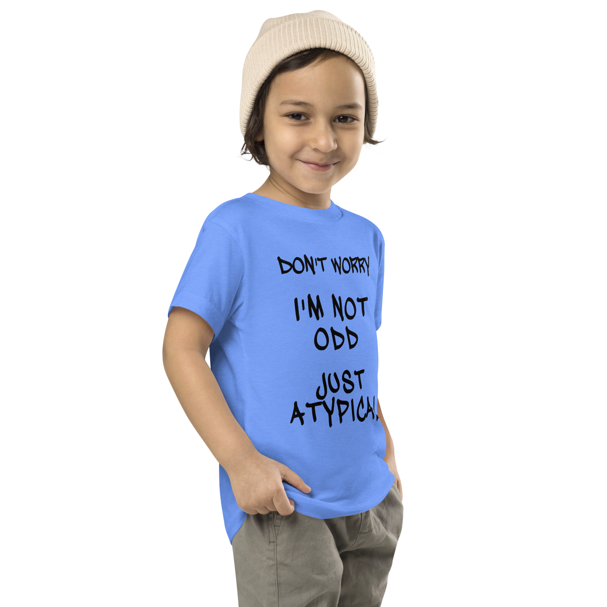 "Don't Worry I'm Not Odd Just Atypical" printed on a heather columbia blue toddler short sleeve tee worn by a male who is also wearing a knit cap