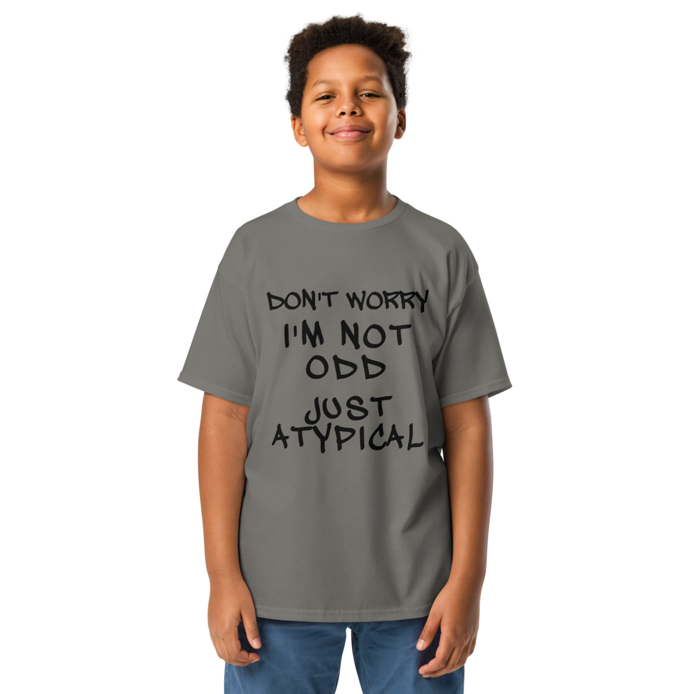 "Don't Worry I'm Not Odd Just Atypical" printed on a charcoal youth classic tee worn by a male