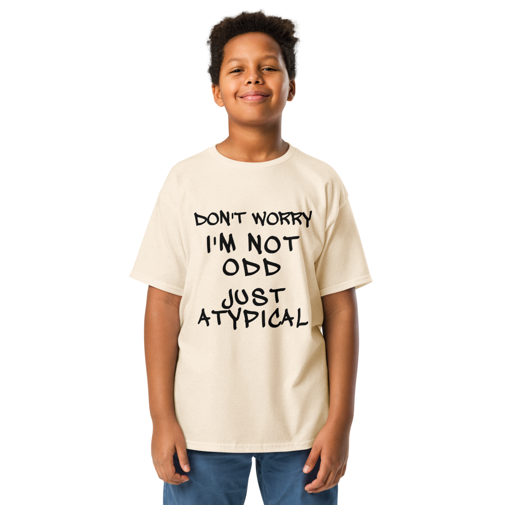 "Don't Worry I'm Not Odd Just Atypical" printed on a natural youth classic tee worn by a male