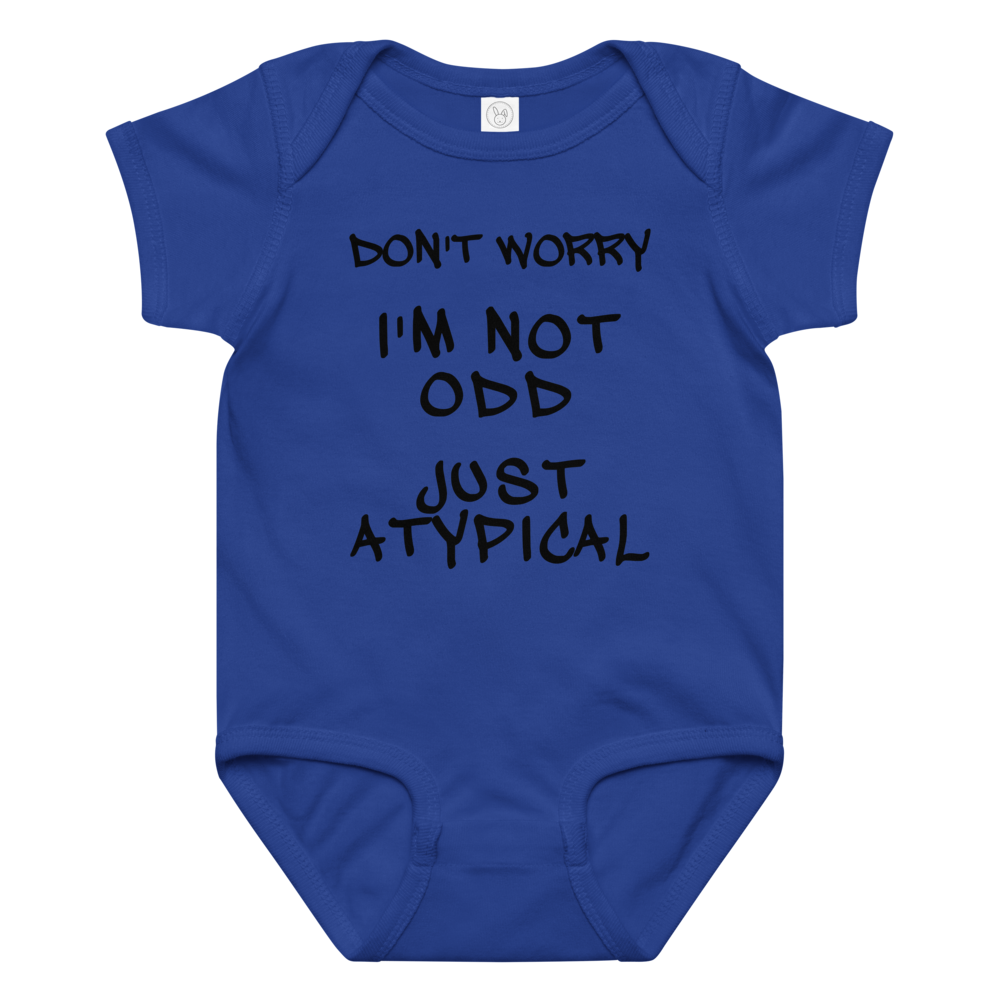 "Don't Worry I'm Not Odd Just Atypical" printed on a royal baby jersey bodysuit laying on a flat surface amongst other clothes