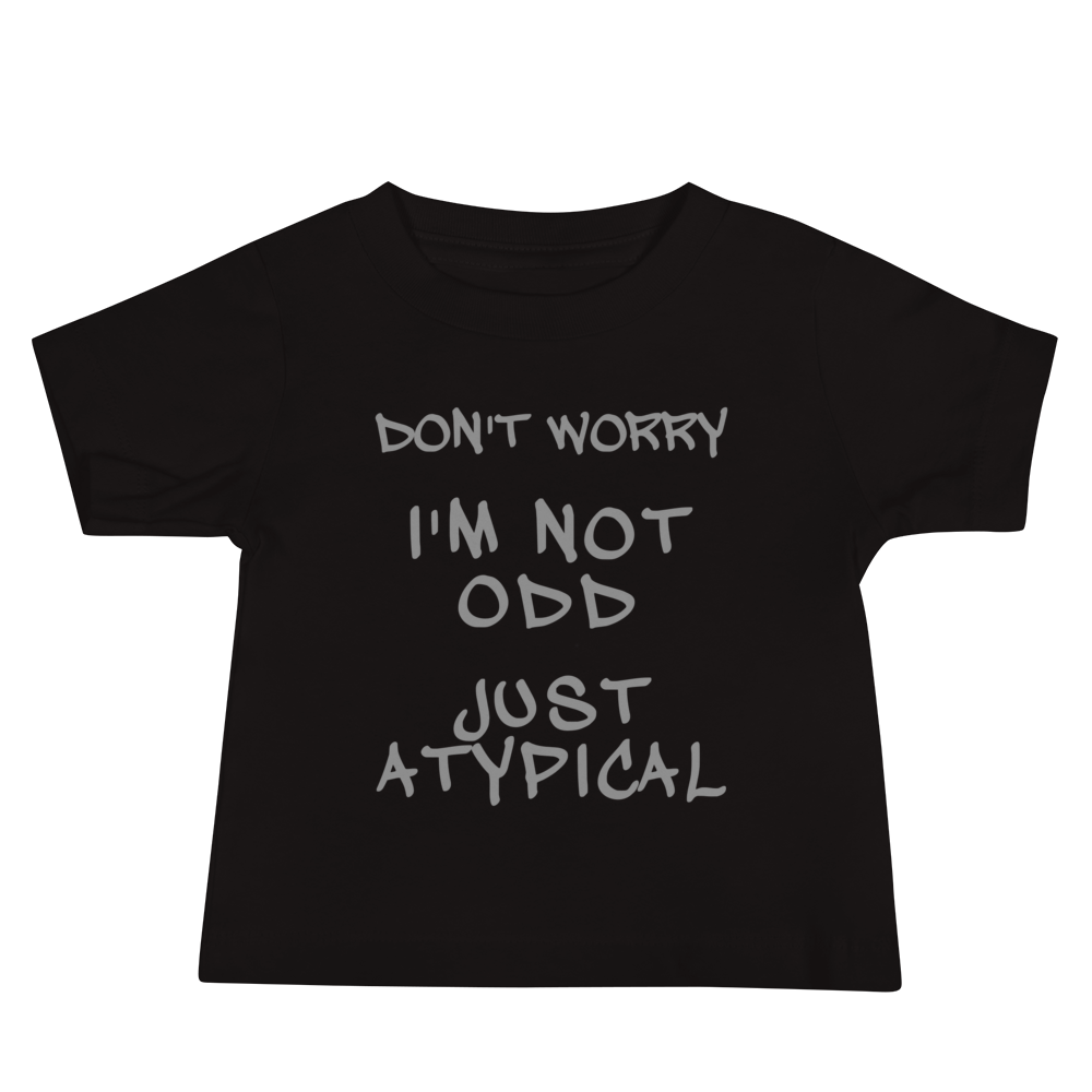 "Don't Worry I'm Not Odd Just Atypical" printed on a black baby jersey short sleeve tee laying on a flat surface