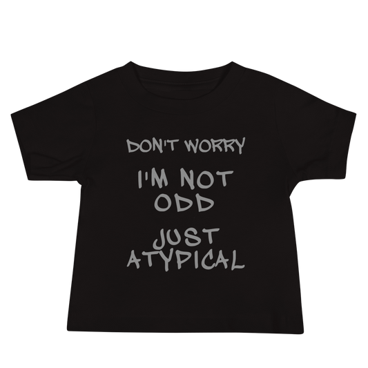 "Don't Worry I'm Not Odd Just Atypical" printed on a black baby jersey short sleeve tee laying on a flat surface