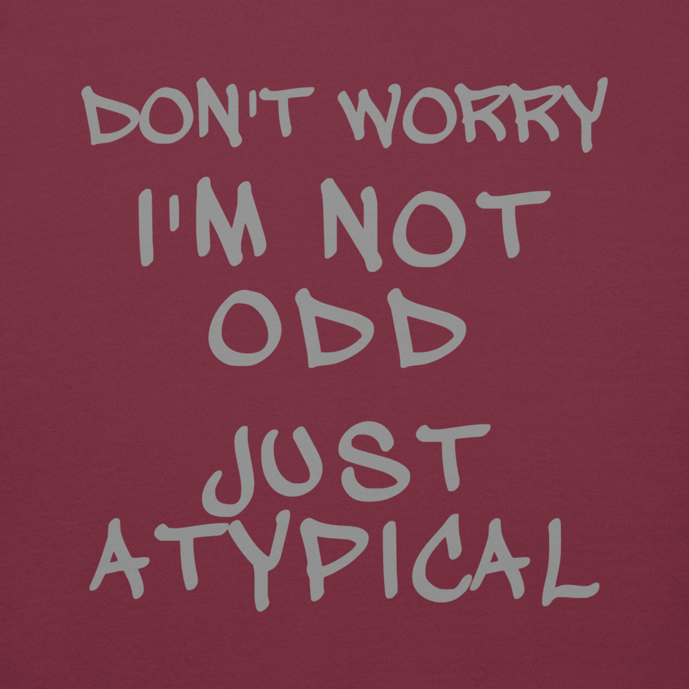 "Don't Worry I'm Not Odd Just Atypical" printed on a maroon background