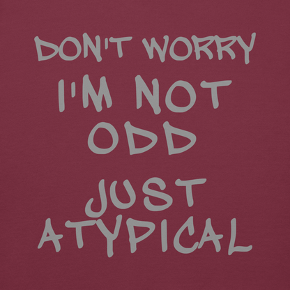 "Don't Worry I'm Not Odd Just Atypical" printed on a maroon background