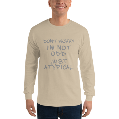 "Don't Worry I'm Not Odd Just Atypical" printed on a sand men's long sleeve shirt worn by a male