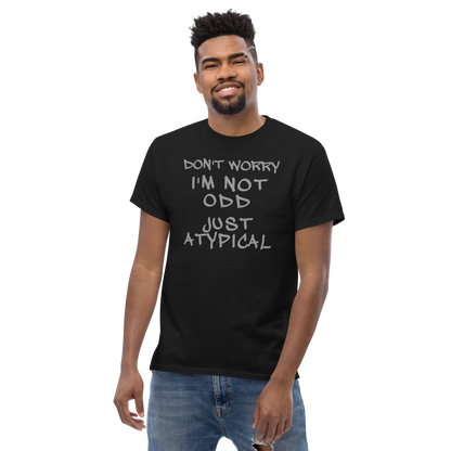 "Don't Worry I'm Not Odd Just Atypical" printed on a black unisex classic tee worn by a male