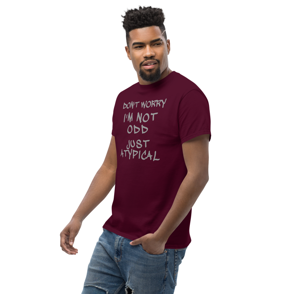 "Don't Worry I'm Not Odd Just Atypical" printed on a maroon unisex classic tee worn by a male