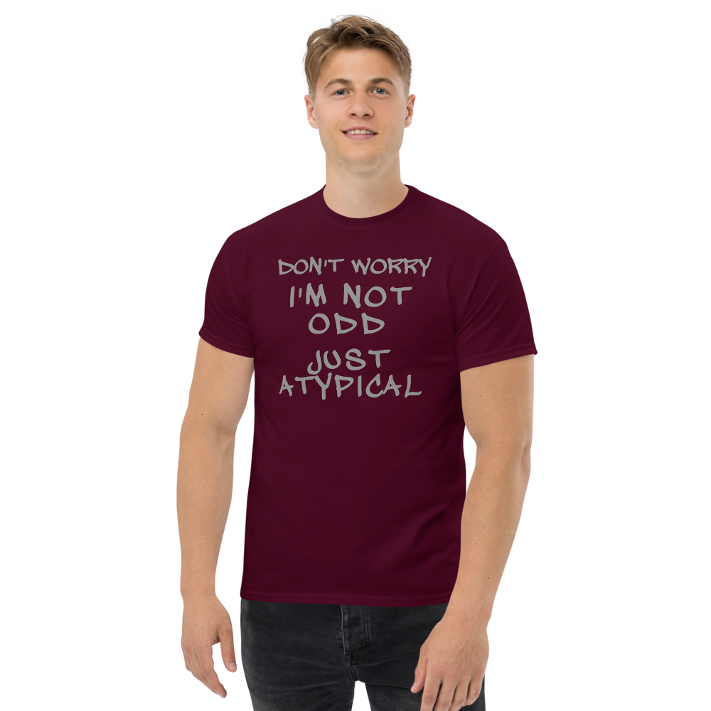 "Don't Worry I'm Not Odd Just Atypical" printed on a maroon unisex classic tee worn by a male
