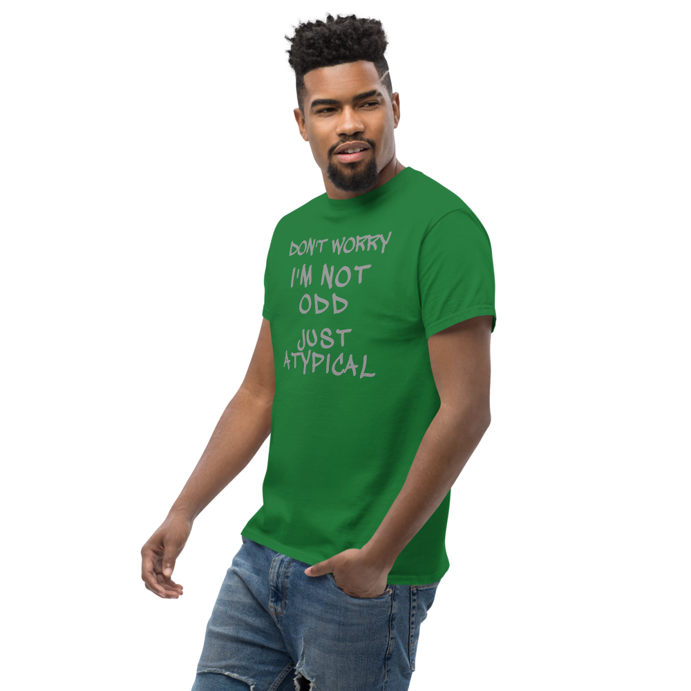 "Don't Worry I'm Not Odd Just Atypical" printed on a turf green unisex classic tee worn by a male
