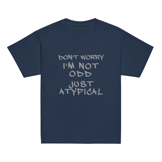 "Don't Worry I'm Not Odd Just Atypical" printed on a navy youth classic tee laying on a flat surface
