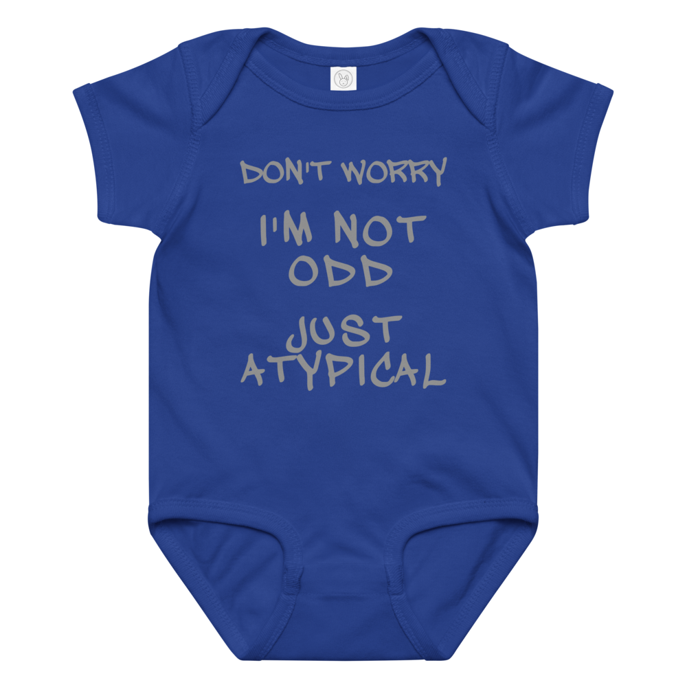 "Don't Worry I'm Not Odd Just Atypical" printed on a royal baby jersey bodysuit laying on a flat surface amongst other clothes
