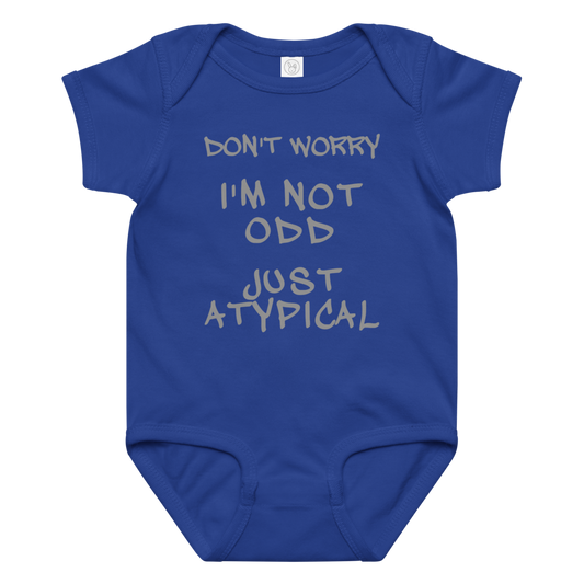 "Don't Worry I'm Not Odd Just Atypical" printed on a royal baby jersey bodysuit laying on a flat surface amongst other clothes