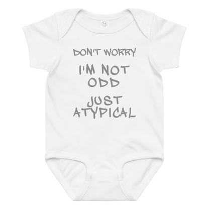 "Don't Worry I'm Not Odd Just Atypical" printed on a white baby jersey bodysuit laying on a flat surface amongst other clothes