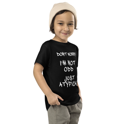 "Don't Worry I'm Not Odd Just Atypical" printed on a black toddler short sleeve tee worn by a male who is also wearing a knit cap