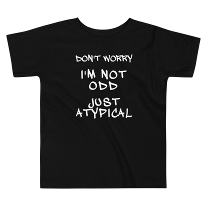 "Don't Worry I'm Not Odd Just Atypical" printed on a black toddler short sleeve tee laying on a flat surface