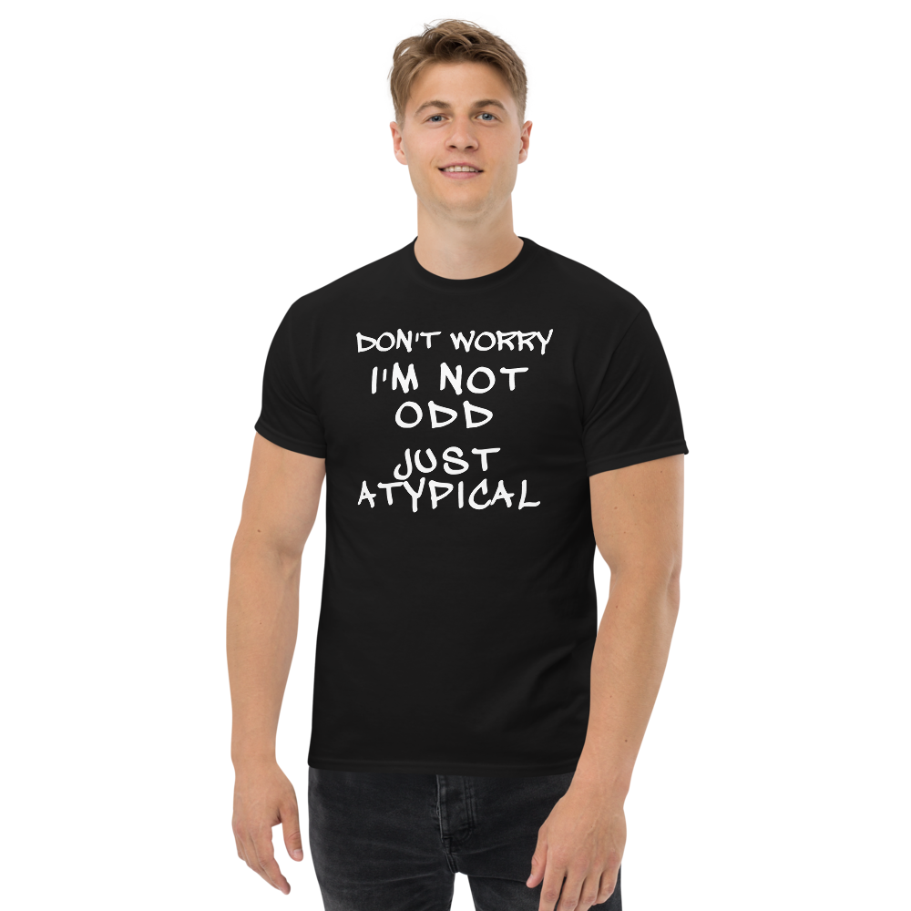 "Don't Worry I'm Not Odd Just Atypical" printed on a black unisex classic tee worn by a male