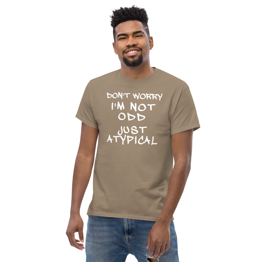 "Don't Worry I'm Not Odd Just Atypical" printed on a brown savana unisex classic tee worn by a male