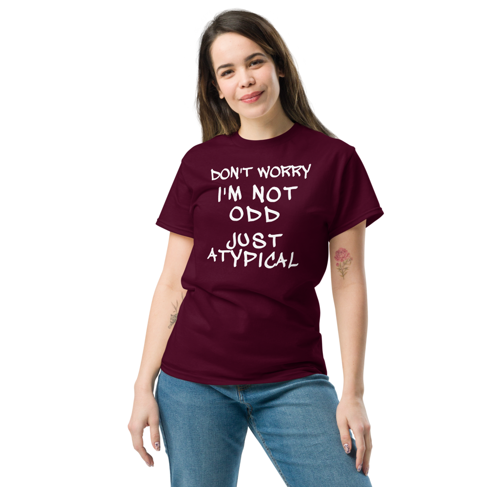 "Don't Worry I'm Not Odd Just Atypical" printed on a maroon unisex classic tee worn by a female
