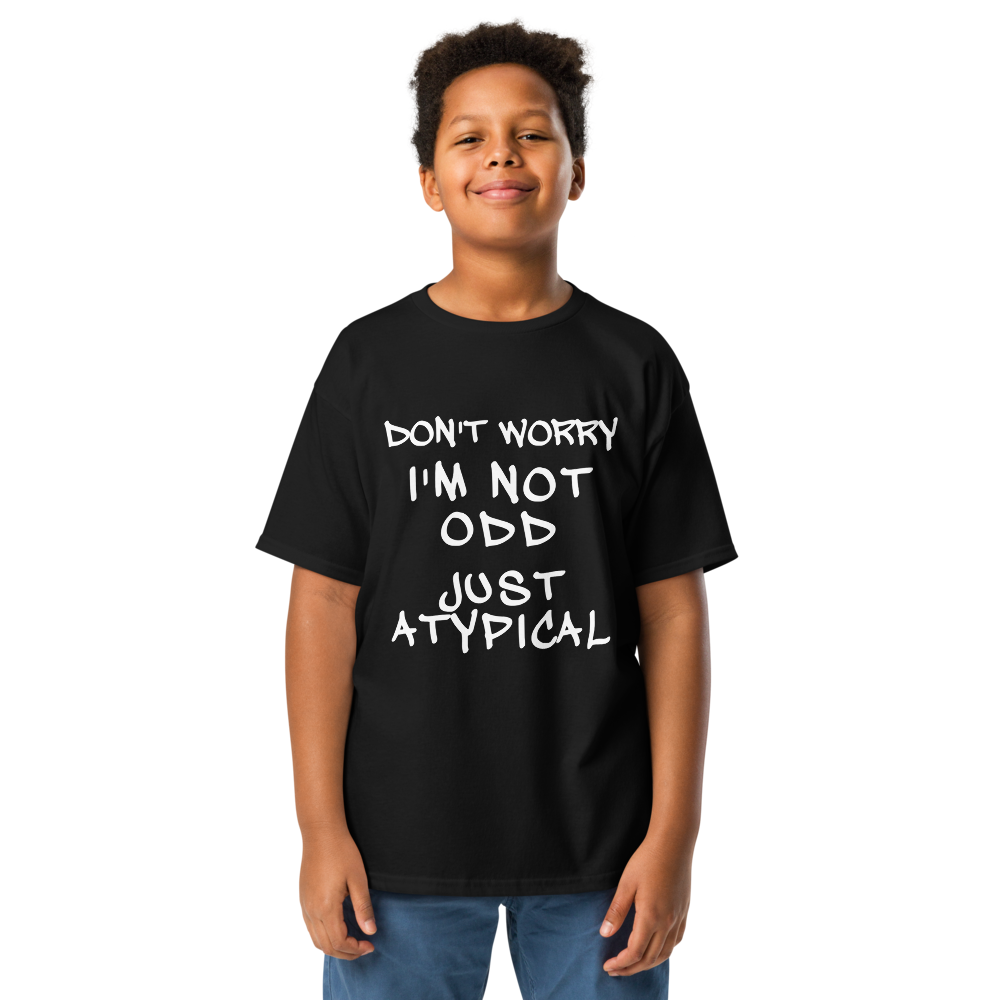 "Don't Worry I'm Not Odd Just Atypical" printed on a black youth classic tee worn by a male