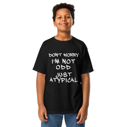 "Don't Worry I'm Not Odd Just Atypical" printed on a black youth classic tee worn by a male