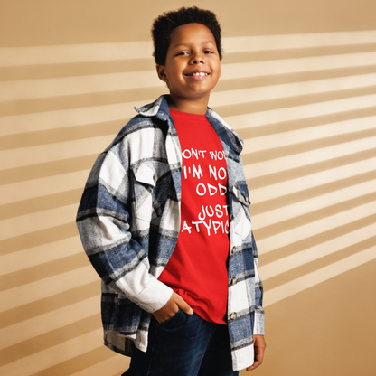 "Don't Worry I'm Not Odd Just Atypical" printed on a red youth classic tee worn by a male also wearing a jacket