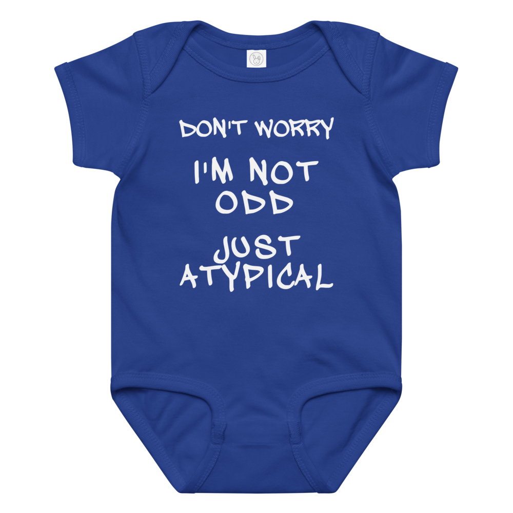 "Don't Worry I'm Not Odd Just Atypical" printed on a royal baby jersey bodysuit laying on a flat surface amongst other clothes