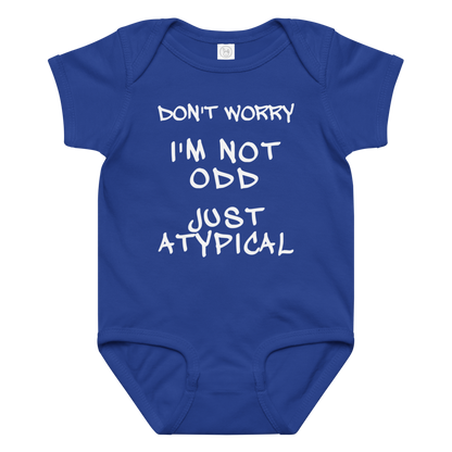 "Don't Worry I'm Not Odd Just Atypical" printed on a royal baby jersey bodysuit laying on a flat surface amongst other clothes