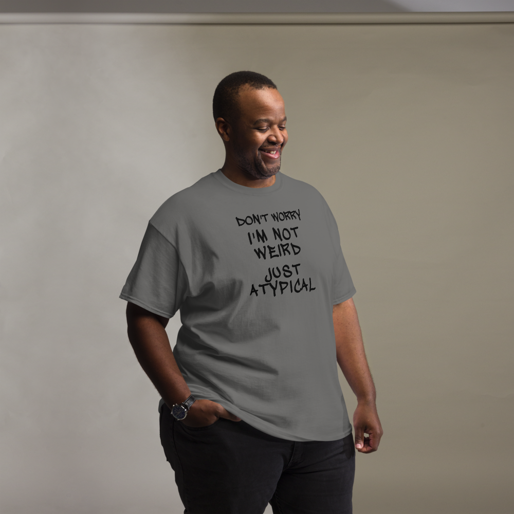 "Don't Worry I'm Not Weird Just Atypical" printed on a charcoal unisex classic tee worn by a male